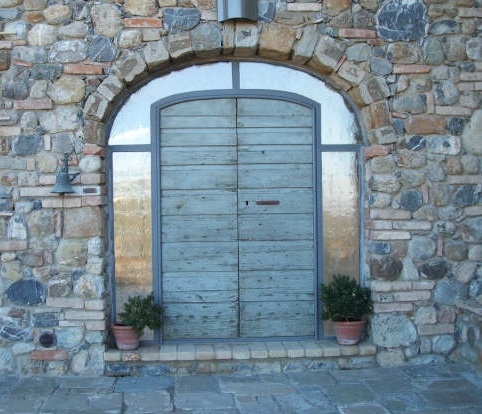 Intelaiatura ad arco in ferro per una porta d'ingresso antica. Vista esterna.